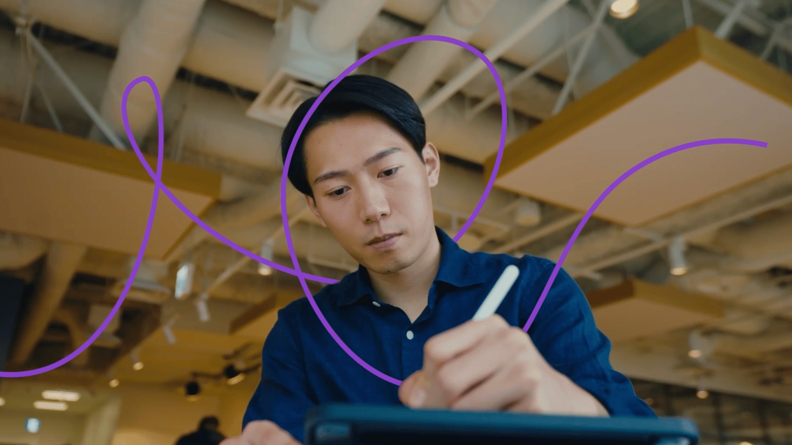 a person sitting at a table writing on a tablet