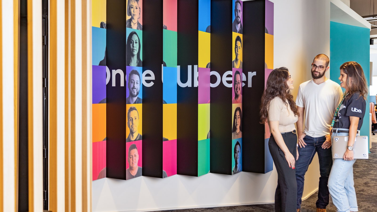 a group of people standing in front of a wall with colorful squares