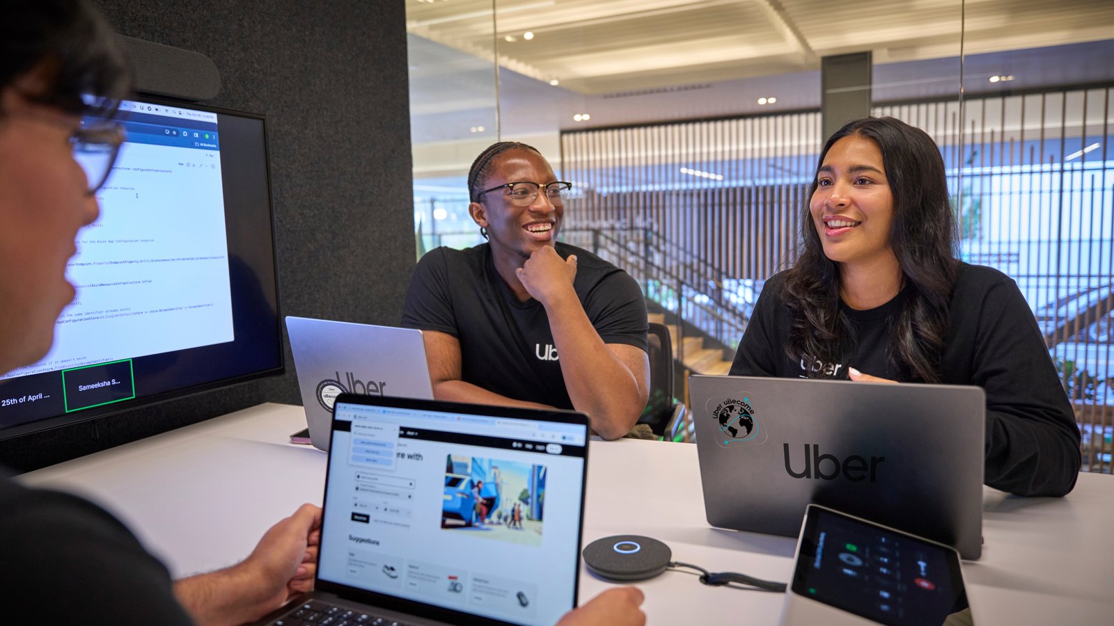 a group of people sitting at a table with laptops