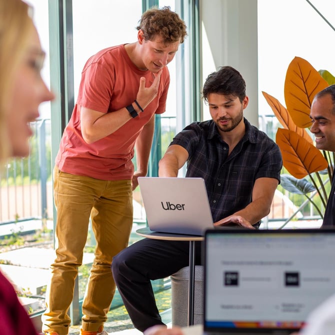 a group of people looking at a laptop