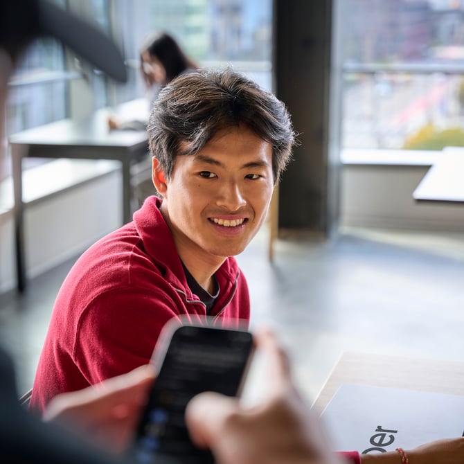 a person smiling at a cell phone