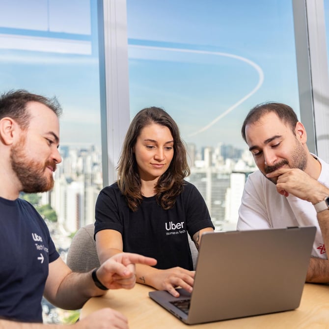 a group of people looking at a laptop