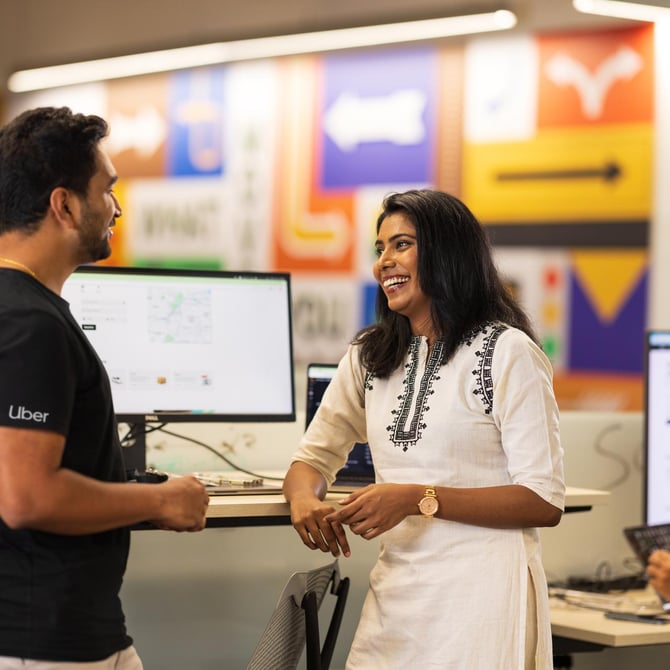 a person and person talking in front of computer screens