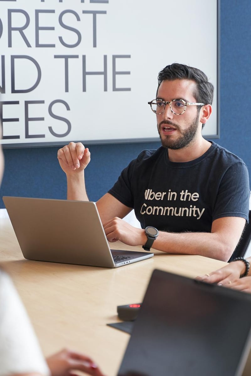 a person sitting at a table with a laptop