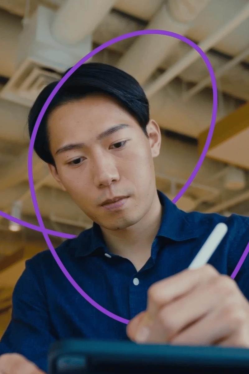 a person sitting at a table writing on a tablet