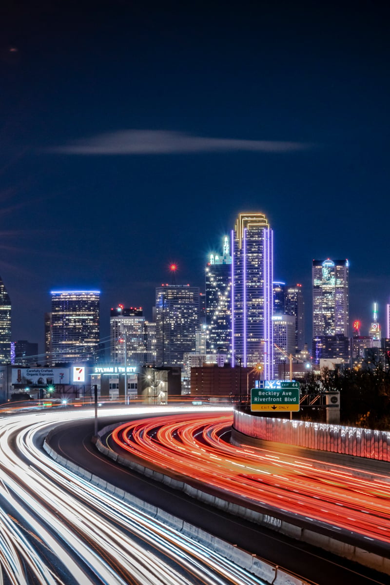 a city skyline at night with a freeway
