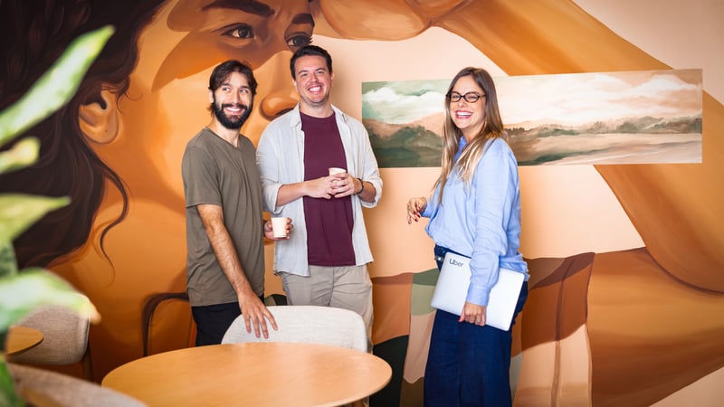 a group of people standing in a room with a mural of a person