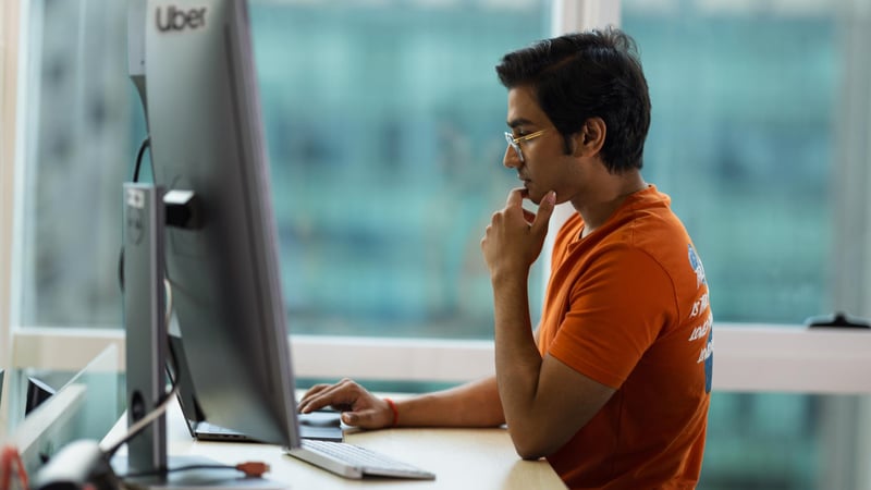 a person sitting at a desk looking at a computer