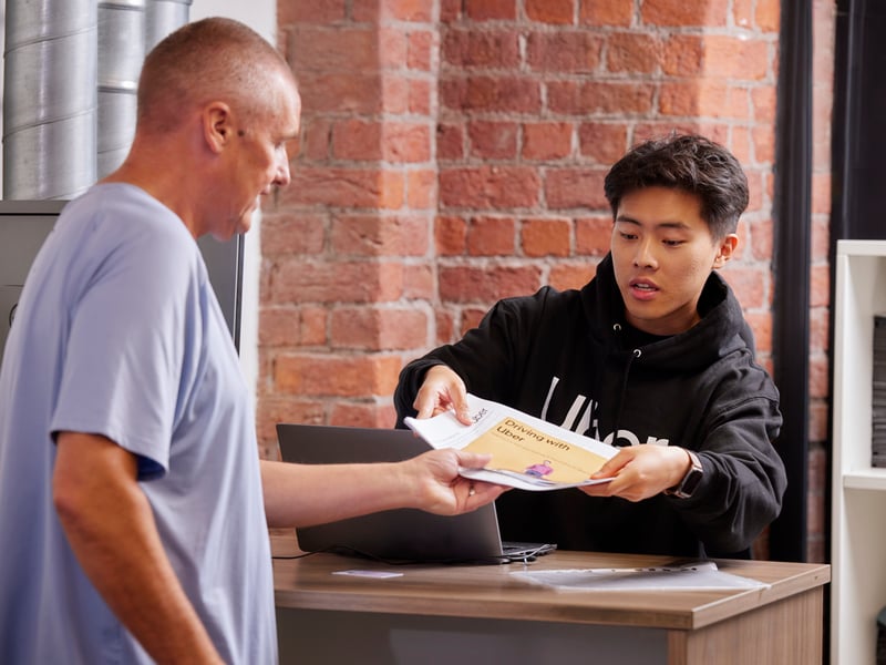 a person handing a paper to a person