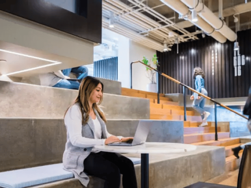a person sitting on stairs with a laptop