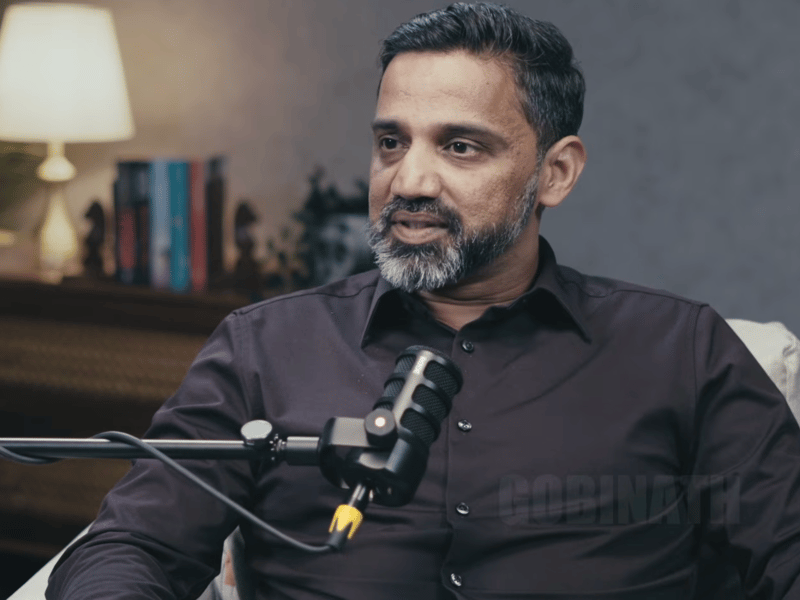 a person with a beard sitting in front of a microphone