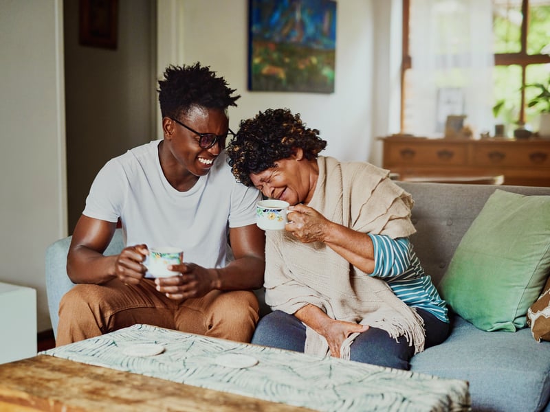 a person and person sitting on a couch and laughing
