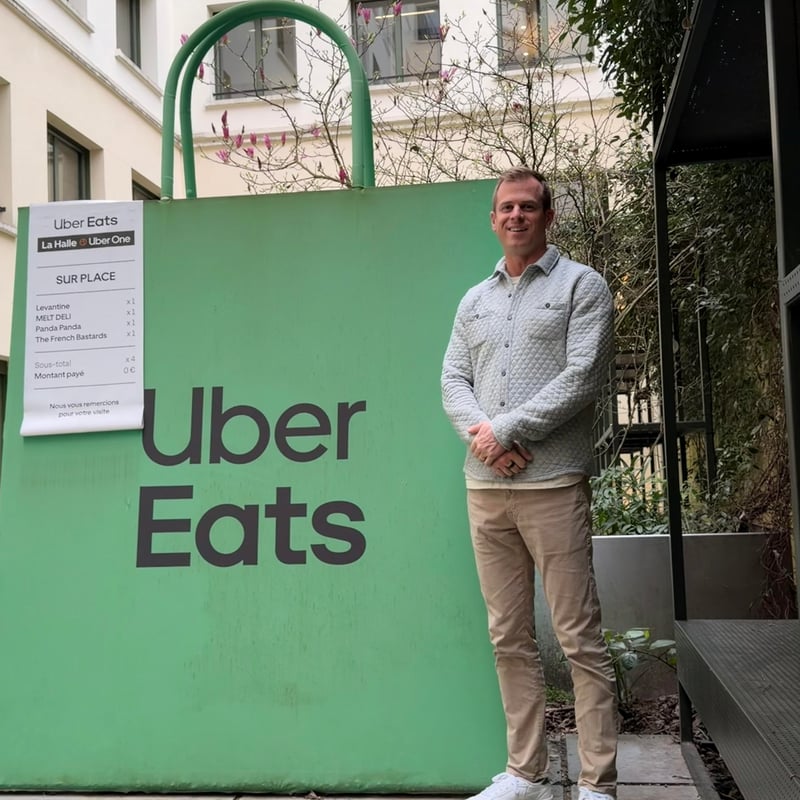 a person standing in front of a green sign