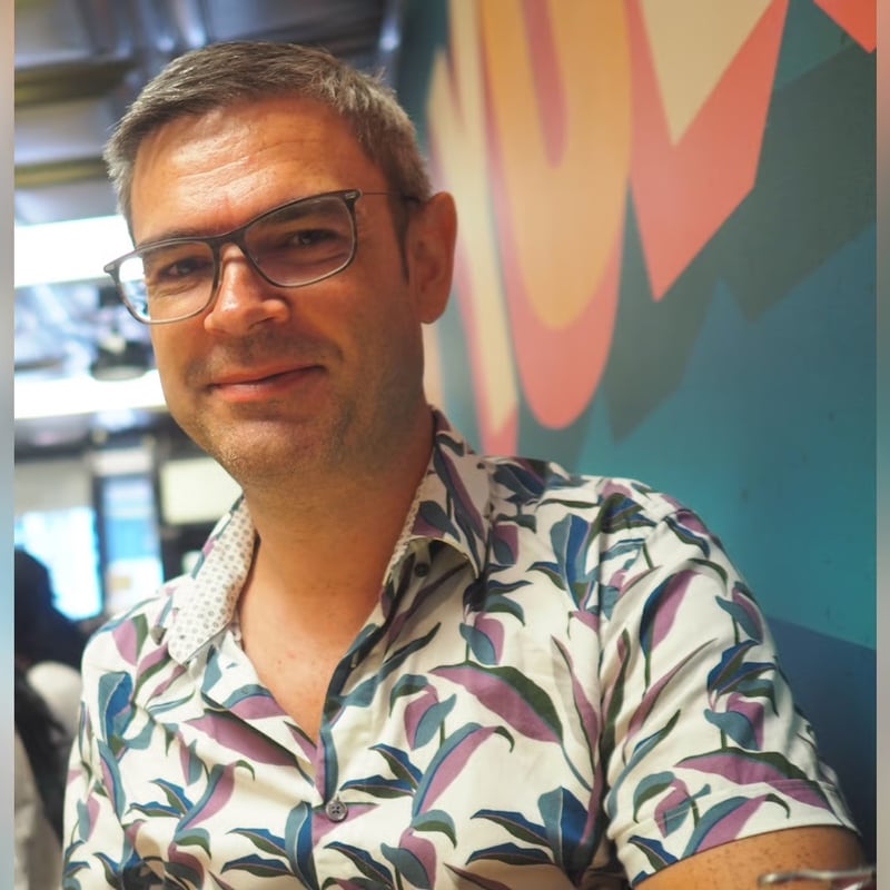 a person wearing glasses and a floral shirt