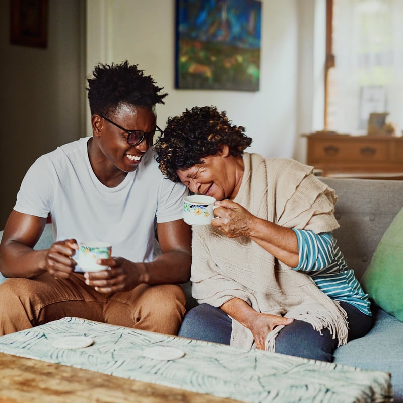 a person and person sitting on a couch and laughing