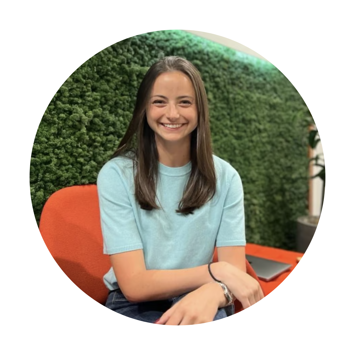 a person sitting on an orange chair smiling