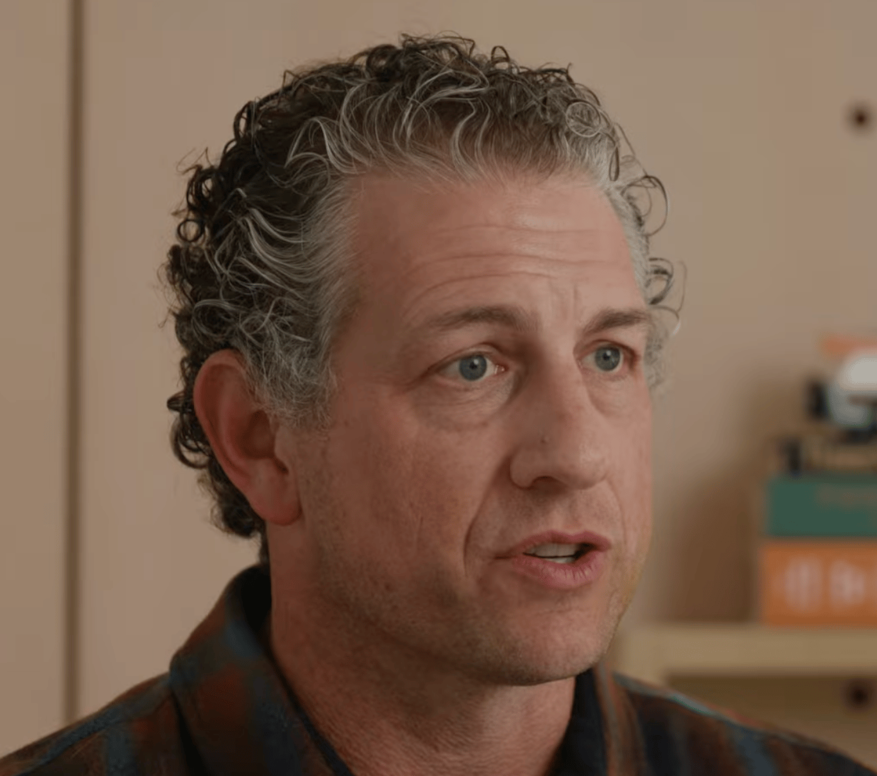 a person with curly hair and blue eyes
