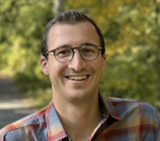 a person wearing glasses and smiling