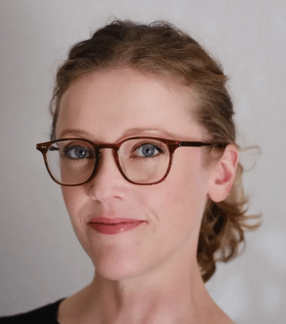 a person wearing glasses and smiling