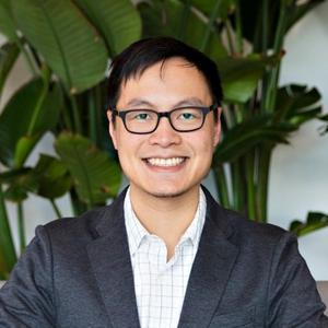 a person in a suit and glasses smiling