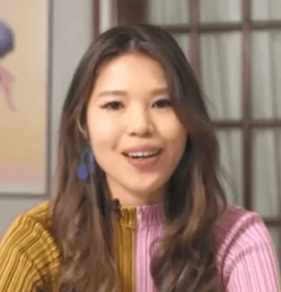 a person with long hair smiling